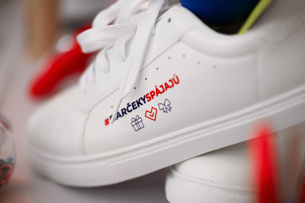 Bielo tenisky s hashtagem a ikonami.