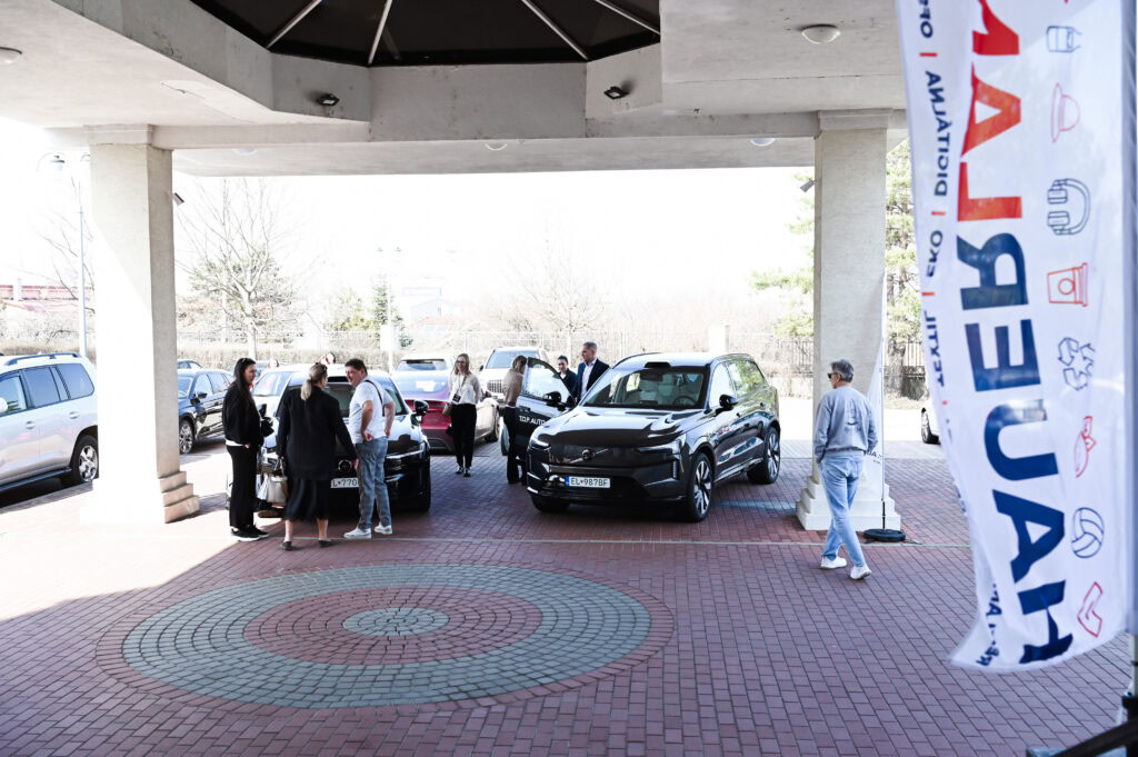 Ľudia diskutujú pri moderných autách vonku