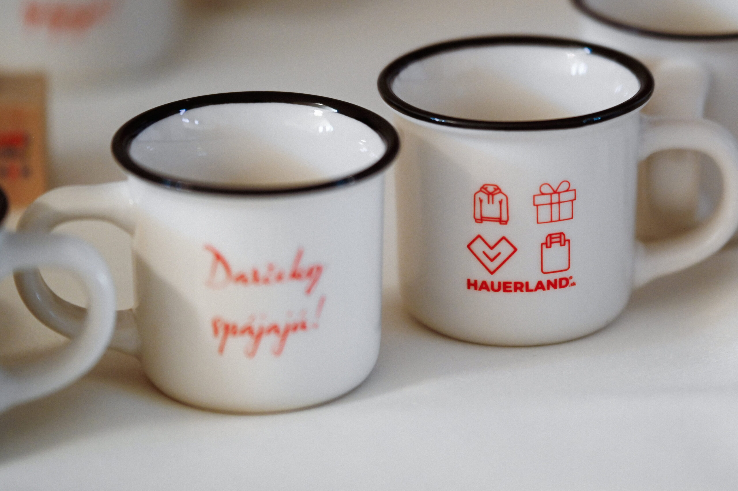 Biele šálky s červenými symbolmi