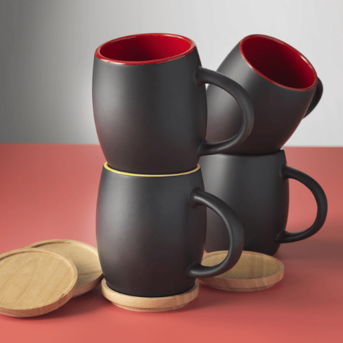 Tri čierne hrnčeky s drevenými podložkami